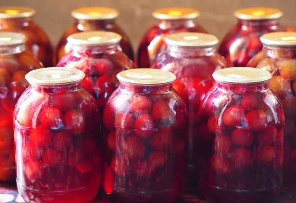Preservation for the winter is in the pantry or cellar. Large glass jars with home preservation of plum compote.