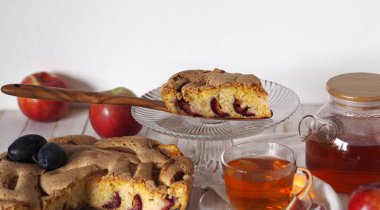 Ev yemeği. Elma ve erikli turta dilimi. Charlotte, çay için ahşap beyaz arka planda..