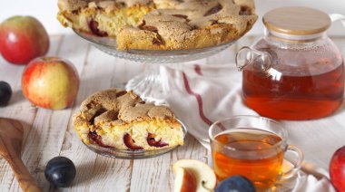 Ev yemeği. Elma ve erikli turta dilimi. Charlotte, çay için ahşap beyaz arka planda..