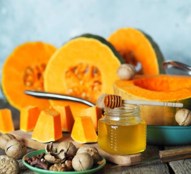 Gri arka planda ballı ve cevizli bir tavada dilimlenmiş portakal kabağı. Ev yemeği. Sonbahar arkaplanı.