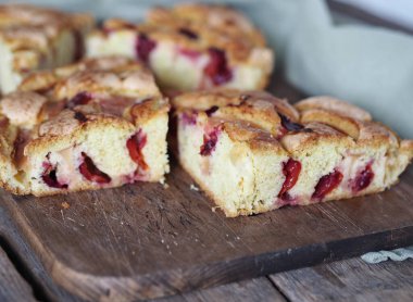 Mutfak tahtasında gri peçeteli taze elma ve erikli elmalı turta parçaları. Köy tarzı. Çay için ev yapımı kekler..