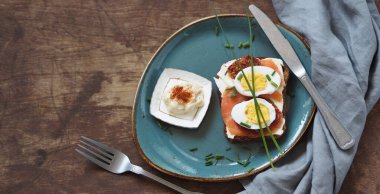 Açık sandviç, peynirli çavdar ekmeği, ahşap zemin üzerinde somon balığı. Sağlıklı doğal kahvaltı..