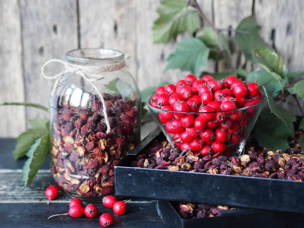 Useful properties of hawthorn berries. Harvesting of dried hawthorn for future use. Fresh red and dried hawthorn on a wooden background.Alternative traditional medicine using hawthorn.