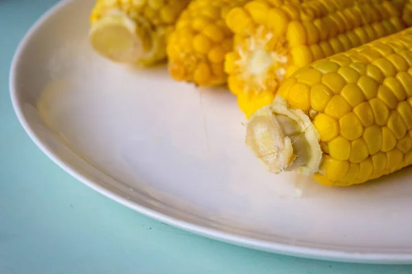 用玉米当食物 蛋白质饮食 烤甜玉米芯特写在灰色背景的白盘上 带有Kopi空间 侧视图 — 图库照片
