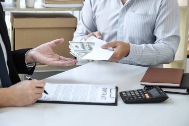 İş adamı, yolsuzluk, yasadışı, sahtekarlık, rüşvet ve yolsuzluk konseptinde anlaşmayı başarıya ulaştırmak için ortaklarının zarfına rüşvet veriyor..