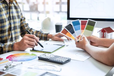 Modern ofiste çalışan grafik tablet ve renk örnekleri üzerine çizim yapan genç İç mimari çalışma evi projesinin takım tasarımı, yaratıcı ilham ve hayal gücü.