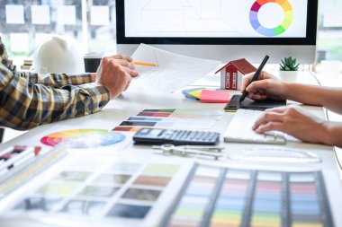 Grafik tablet ve renk örnekleri üzerinde çalışan, modern ofiste ev projesi, yaratıcı iş yeri ilhamı ve hayal gücü üzerine çalışan genç İç mimar takımı..