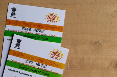 Birbhum, Batı Bengal / Hindistan - 18 Ağustos 2020: Hindistan 'ın Aadhaar kartları ve kahverengi ahşap masa üzerindeki kalem