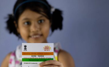 Birbhum, Batı Bengal / Hindistan - 31 Ağustos 2020: Hindistan 'ın Aadhaar kartı kimliği seçici odaklı güzel bir Hintli kız çocuğu tarafından elde tutuldu