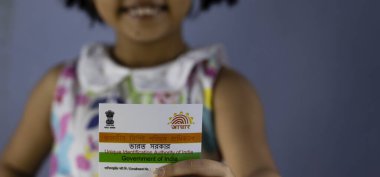 Birbhum, Batı Bengal / Hindistan - 31 Ağustos 2020: Hindistan 'ın Aadhaar kartı kimliği seçici odaklı güzel bir Hintli kız çocuğu tarafından elde tutuldu