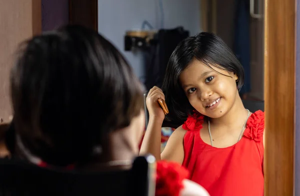 Симпатичная Индийская Девочка Красном Платье Расчесывает Волосы Смотрит Камеру Перед — стоковое фото