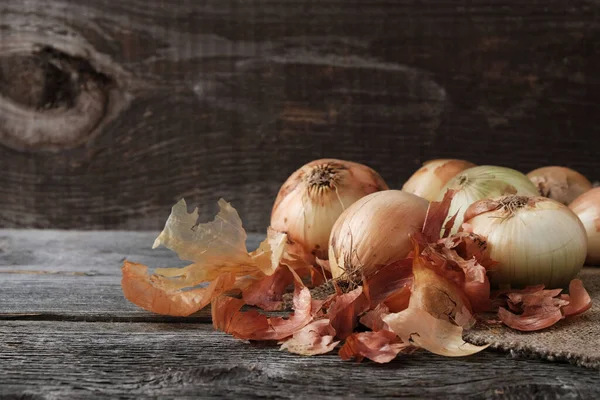 onion bulbs and onion skins on an old vintage wooden background with copy space.