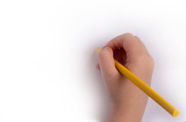 Çocukların yaratıcılığı kavramı. Kağıttan yapılmış el işleri, beyaz bir masanın üzerinde çocuk eli olan renkli kalemler. Çocuk sanat sınıfı, anaokulu, anaokulu eğitimi..