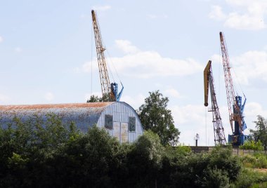 Mavi gökyüzüne karşı eski hangar ve turnalar