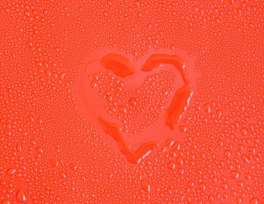 Kırmızı arkaplanda ana hatlarıyla su damlaları var. Yakın plan.