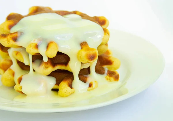 Beyaz tabaklı geleneksel waffle 'lar. Beyaz kremayla kaplı.