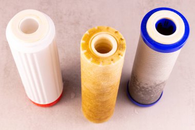 Kirli içme suyundan sonra masada üç filtre vardır.