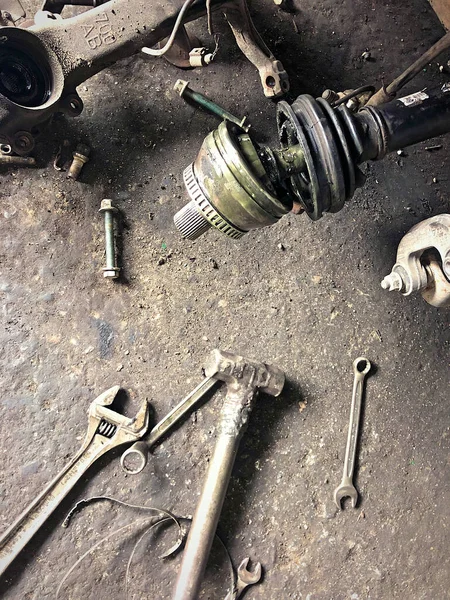车库里用工具固定轮式汽车是指在肮脏的水泥地面上的扳手 锤头和结 — 图库照片