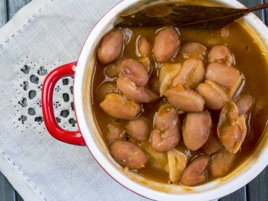 Stewed pinto beans (Fabada), typical Spanish banana, bread on white tablecloth clipart