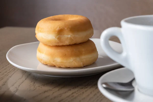 Dwa Świeże Pączki Śniadanie Drewnianym Stole Kubek Espresso — Zdjęcie stockowe