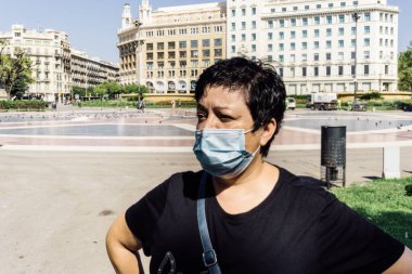 Coronavirus COVID-19 yüzünden Barcelona 'da maskesi olan orta yaşlı bir kadın.