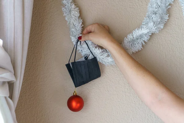 Mulher Colocando Ornamento Natal Com Bola Vermelha Máscara Período Pandêmico — Fotografia de Stock