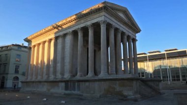 Nme, Gard, Occitanie, Fransa. Roma tapınağı M.Ö. 4-7 yılları arasında tarihlenmiştir, arka planda Norman Foster 'ın 1993 yılında açtığı Carree d' Art vardır..