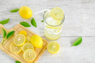 Beyaz ahşap bir masada limon suyu ve taze limon..