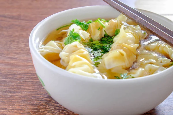 Tahta masadaki bir kasede Wonton Çorbası Hamur köftesi