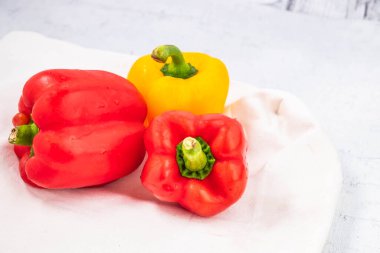 Taze kırmızı ve sarı dolmalık biberler beyaz ahşap üzerinde