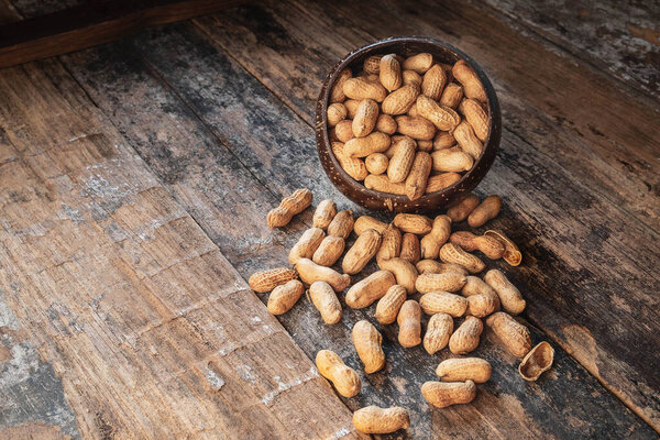 Peanut in a bowl on wood background