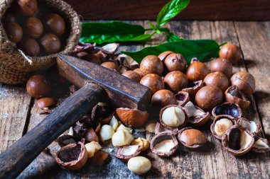 Tahta zeminde bir çuvalda Macadamia fındığı.