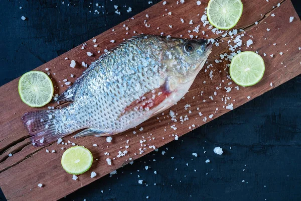 Tahta üzerinde taze tilapia balığı.