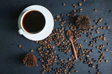 Kahve fincanı ve kızarmış kahve çekirdekleri.