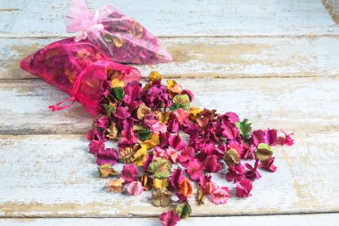 Ahşap arka planda çiçek parfümü torbası