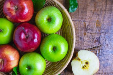 Tahta bir arka planda yeşil elma ve kırmızı elma.