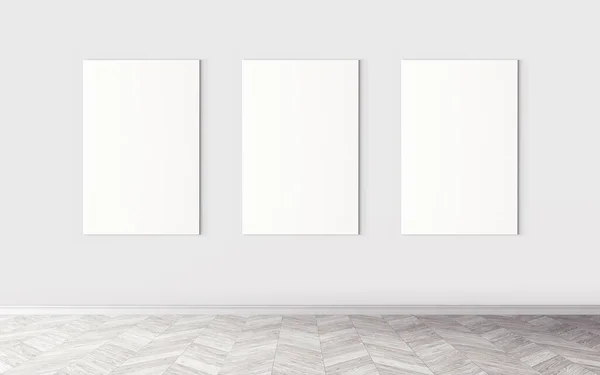 Three white empty canvases on wall. Mockup for you design preview. Good use for advertising materials.