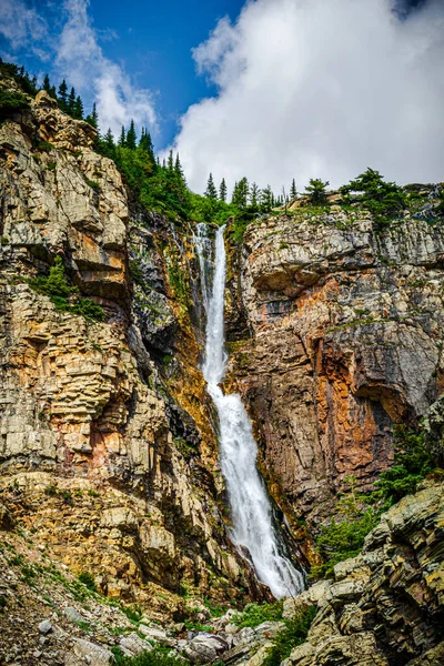 5076 The Apikuni Falls are nestled among the rugged mountain cliffs at Glacier National Park Montana