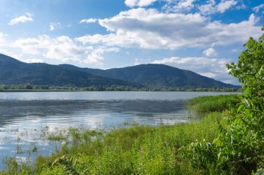 Kırsal alanlar, göl ve tepeler, bulutlu mavi gökyüzü manzarası fotoğrafları..