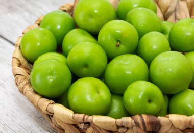 Tahta sepetteki yeşil eriklerin fotoğrafları.