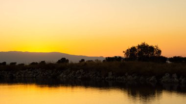 Gün batımı manzarası. Deniz yaz doğası. Ufukta dağlar olan panoramik deniz manzarası. günbatımı deniz manzarası