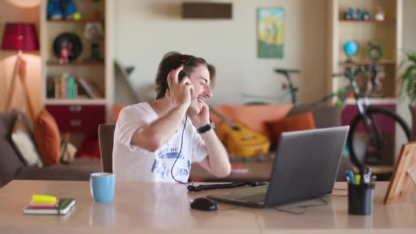 Парень слушает музыку на ноутбуке с наушниками Лицензионные Стоковые Видеоролики
