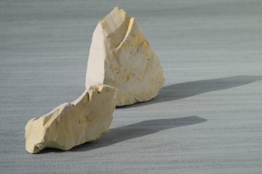 Cyan arka planda parçalanmış beyaz kil. Kapatın. Ural gıda çamuru. Kimse yok.