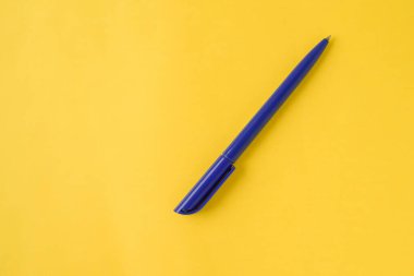 Sarı arka planda mavi kalem. Üst Manzara. Minimalizm. Geçmişi temiz görünüyor. Düz yatıyordu. Kopyalama alanı ile şablon. Bir nesne. Konsept başbakanlık, ofis malzemeleri