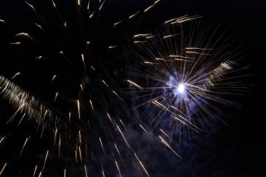 Gece gökyüzüne karşı ışıldayan havai fişekler. Kutlama için soyut arka plan Mutlu Noeller, doğum günleri, Zafer Günü, bağımsızlık, tatiller, kutlama, parti, festival, yeni yıl konsepti