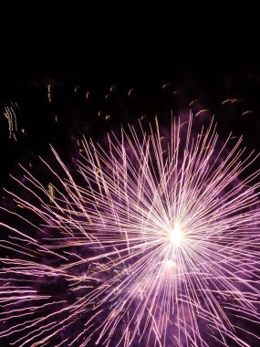 Gece gökyüzüne karşı ışıldayan havai fişekler. Kutlama için soyut arka plan Mutlu Noeller, doğum günleri, Zafer Günü, bağımsızlık, tatiller, kutlama, parti, festival, yeni yıl konsepti