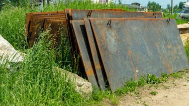 Üstüste yığılmış paslı demir çarşaflar.