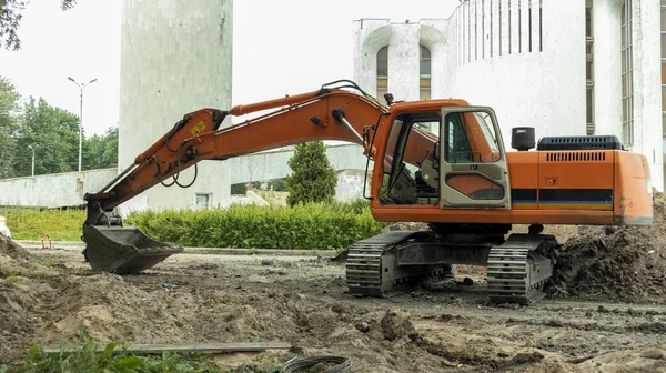 İnşaat alanının yakınındaki turuncu inşaat kazıcısı