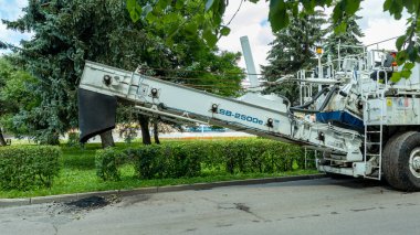 Kaldırımın kenarında, ağaçların arka planında beyaz bir kaldırım var.