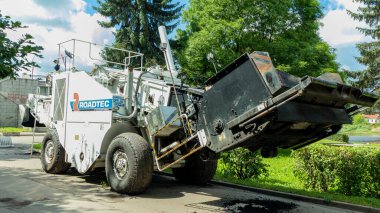 Kaldırımın kenarında, ağaçların arka planında beyaz bir kaldırım var.